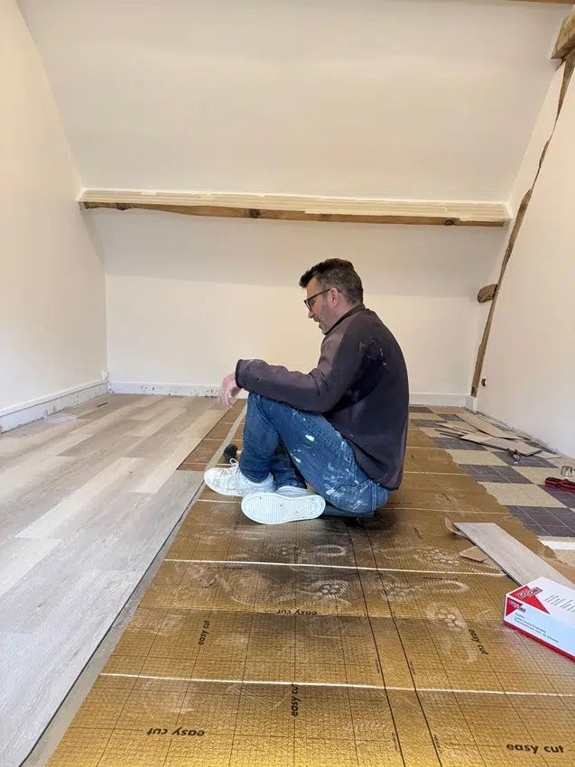 Henry, propriétaire du gîte, pose la parquet